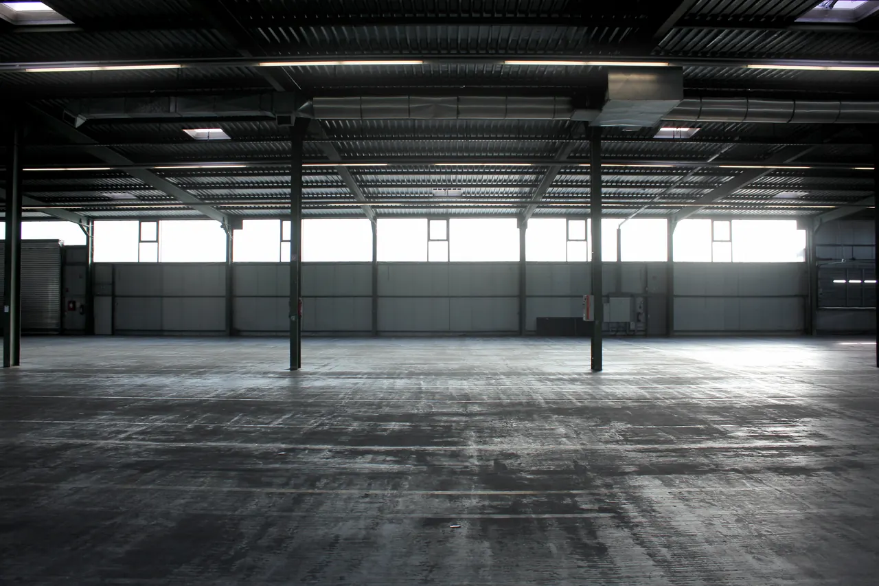 Innenansicht der Logistikhalle der Jashari GmbH mit Stahlträgern und Fensterband